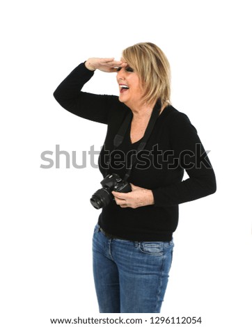 Happy middle aged woman laughing while holding a camera against a white background