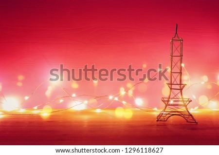 Valentine's day background. Eiffel tower over wooden table and red bakground