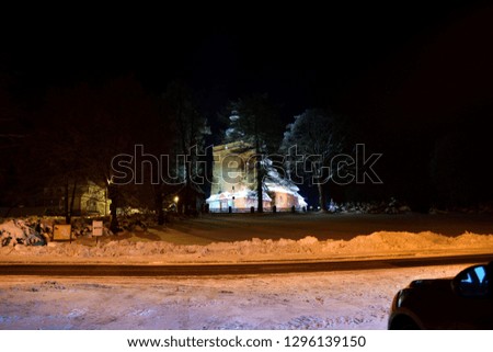 historic wooden church illuminated at night photography in the snowy winter