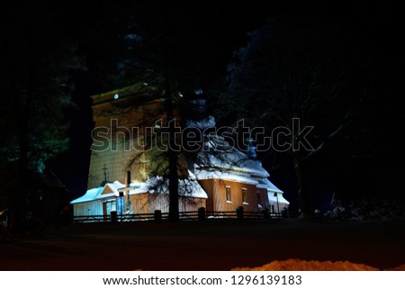 historic wooden church illuminated at night photography in the snowy winter
