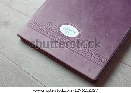 pink photo book with  fabric cover..
Photo book on a light background.

Photo album with a hard cover on a wooden background.
Bright  photo album.
