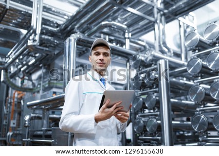 Technologist with a tablet in his hands at the dairy plant