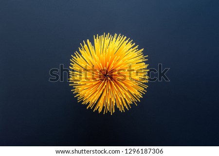 spaghetti pasta in the shape of a flower on a black background Royalty-Free Stock Photo #1296187306
