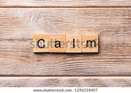 calm word written on wood block. calm text on wooden table for your desing, concept.
