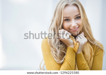 Closeup portrait of young attractive woman outdoors with copy space. Beautiful blond girl model. Cheerful lady on neutral background spring, fall, autumn.