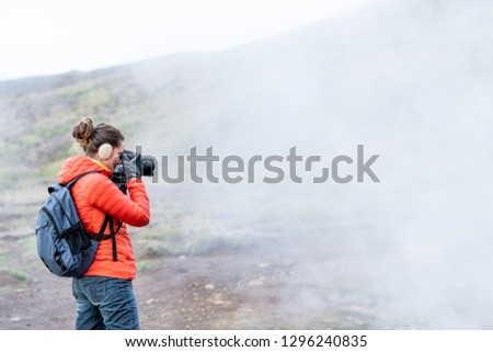 Reykjadalur, Iceland Hot Springs road footpath with steam fumarole vent during cold autumn day in golden circle with people woman girl taking picture photographing