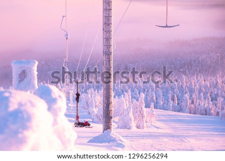 Kuusamo Ruka. Finland Lapland. Ski resort. The man at the top of the column, repair of the lift. Early morning.