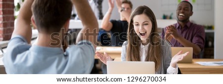 Horizontal concept photo happy coworkers clap hands congratulate each other with business success reached common aim, focus on woman looking at pc received great news, banner for website header design