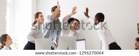 Happy diverse workmates giving high five celebrating corporate success feels excited in workplace, succeed common goal career growth concept, banner for website header design with copy space for text Royalty-Free Stock Photo #1296270064
