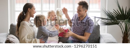 Horizontal photo happy family little kids sitting on sofa celebrating father day presenting gift box make surprise congratulate birthday, life events holidays concept, banner for website header design