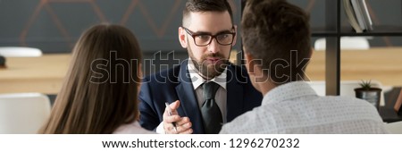 Rear back view couple meets with realtor real estate agent in office, consulting services, bank worker and loan, human resources recruitment concept, horizontal photo banner for website header design Royalty-Free Stock Photo #1296270232