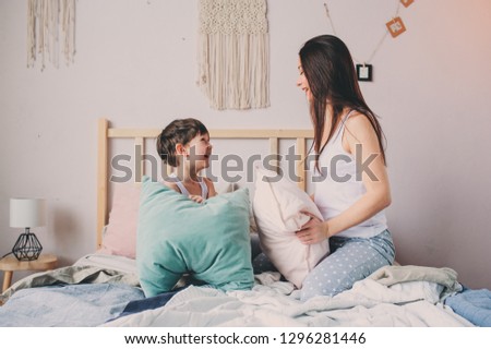 happy mother and child son playing pillow fight in bed in early morning. Family casual lifestyle series.