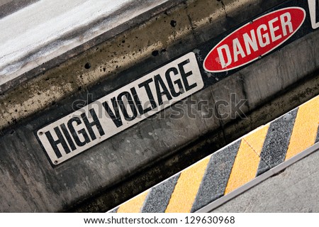Danger high voltage warning sign with black and yellow hazard stripes.