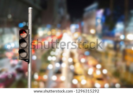 Traffic light with abstract blurred traffic jam background.