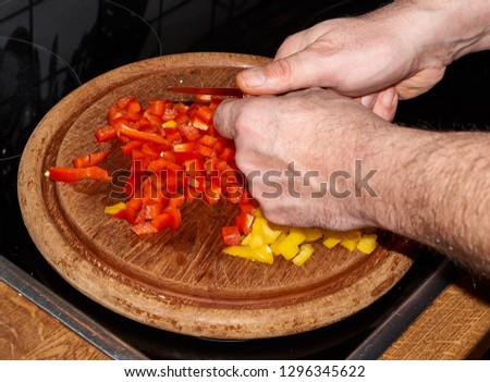 Yellow and red peppers Capsicum cut with a knife on a board.