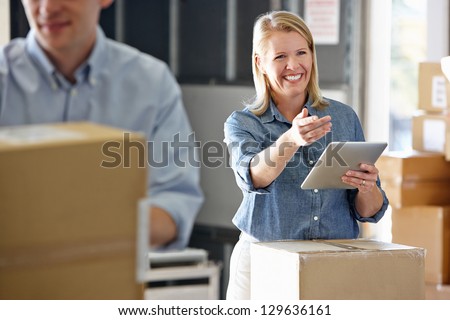 Manager Using Tablet Computer In Distribution Warehouse Royalty-Free Stock Photo #129636161