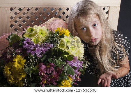 Girl in the studio in a black dress and bouquet