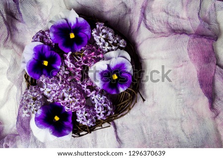 Violet flowers arrangement on purple textile top view