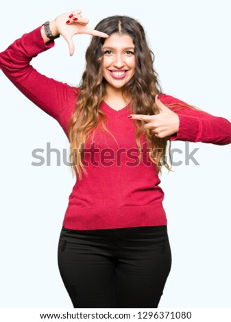 Young beautiful woman wearing red sweater smiling making frame with hands and fingers with happy face. Creativity and photography concept.