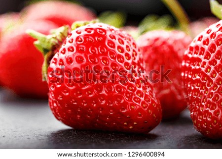 A lot of ripe strawberries scattered on a black background. space for text
