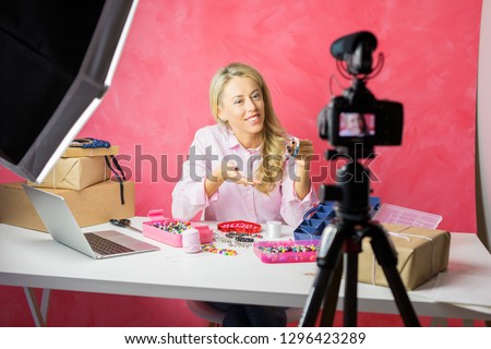 Social media influencer young woman recording video blog with instructional how-to tutorial for making your own jewellery.