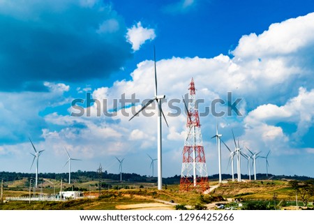 Wind turbines Geneating Clean Energy and Electricity in Blue Sky with High Electricity Post, Thailand.