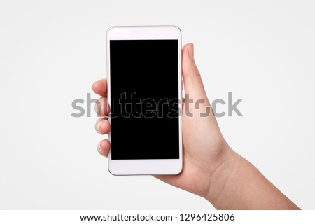 Unrecognizable woman holds smart phone with blank screen for your promotional content or advertisement, isolated over white background. Technology concept. Modern electronic device, mock up. Royalty-Free Stock Photo #1296425806