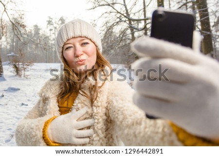 young women making selfie in winter forest