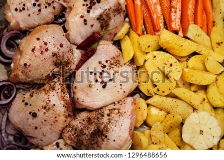 Raw ingredients - chicken, carrots, potatoes for cooking a dish of baked potatoes with chicken legs