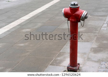 Red fire hydrant in a city street for firefighters