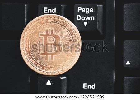 concept bitcoin cryptocurrency virtual cash. btc coin lays at black keyboard. rip bitcoin collage. toned matte. dramatic light. low exchange rates trend. for design or decor.