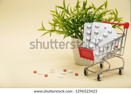 Shopping trolley with pills and medicine. Pills in shopping cart on blue background. The concept: trade in medicines, pharmacies.
