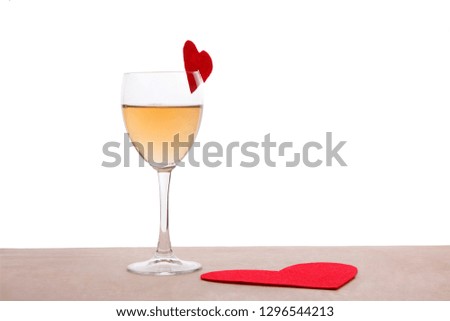 Glass and red paper forms of heart for Valentine's Day on the wood table