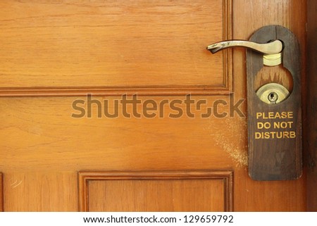 Do not disturb sign hanging on a hotel door handle Royalty-Free Stock Photo #129659792