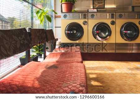 Coin-operated washing machines at a vintage laundromat Royalty-Free Stock Photo #1296600166