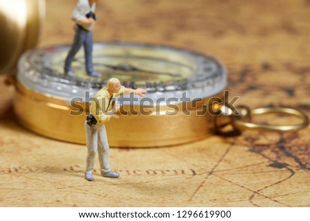 Travelling concepts. Group of traveler miniature mini figures with camera standing and walking on old world map 