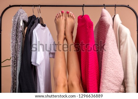 funny girl's legs. woman is looking for a trousers in the shop. close up photo. madness during shopping. girl has taken off her jeans in the fitting rom.