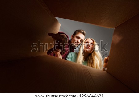 Picture of woman and man looking inside cardboard box