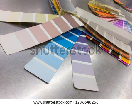 Color fan deck with samples of various paint on a metallic table