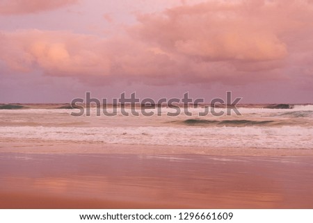 pastel pink sunset australian beach scene with waves and clouds