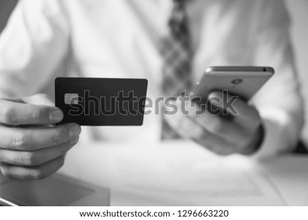 Smartphone and Internet Commerce. Online trading on the currency exchange. Young businessman with a bank credit card in his hands. Payment of goods online. Online payments through the phone.