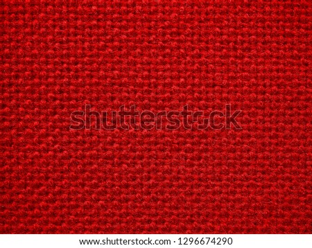 Close-up of the red textile texture, background and wallpaper. The texture of red fabric textile upholstery of furniture. High-quality macro photography.