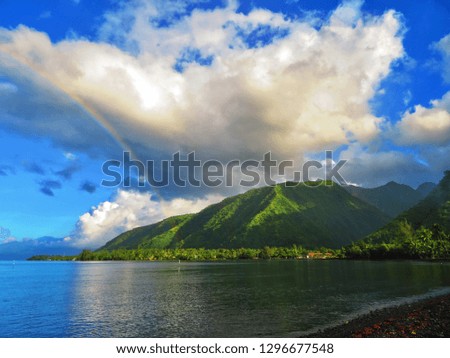 rainbows over the mountains and ocean in tahiti