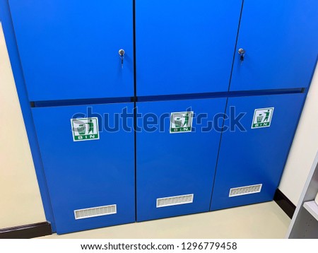 Bin on the floor in blue cabinet in laboratory. hazardous waste control.