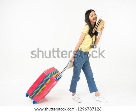 Beautiful young woman smiling and pulling pink color luggage isolated on white background.Asian woman going to summer vacation.Travel trip funny.
