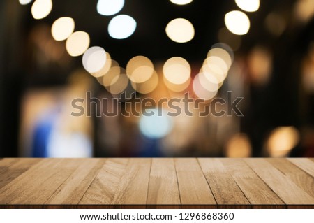 wood table in front of blur super market background.