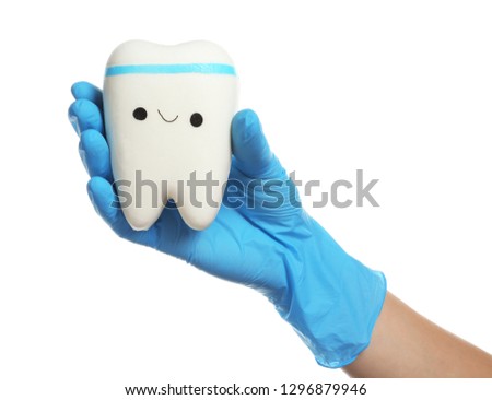Dentist holding model of tooth with cute face on white background