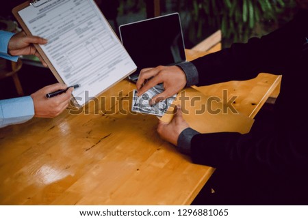 Asian business individual who owns the business sign personally sealing the deal with receiving a bribe money.The concept of corruption and anti bribery

