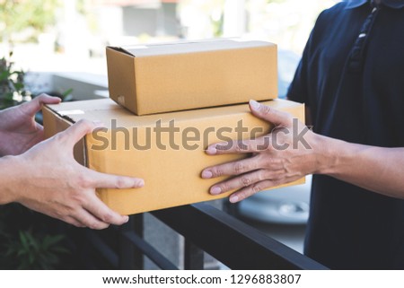 Delivery mail man giving parcel box to recipient, Young owner accepting of cardboard boxes package from post shipment, Home courier and delivery service mind concept.