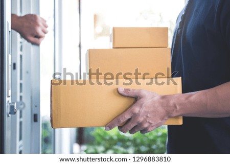 Home owner open door to delivery man standing with parcels in hands outdoors, Home delivery service and working with service mind.